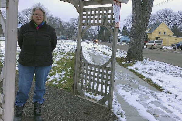 Edna Sabucco, stands near her house in Flint, Mich. Tuesday, Jan. 12, 2021. Former Michigan Gov. Rick Snyder, top aide Rich Baird and his health director Nick Lyon have been told they will face charges resulting from the Flint water crisis, according to a source with knowledge of the situation. Sabucco said she still uses water filters, although the lead service line at her home of 40-plus years has been replaced, along with more than 9,700 others in Flint. (AP Photo/Tammy Webber)