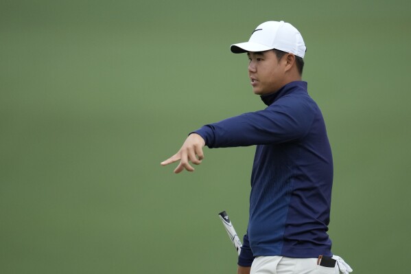 Tom Kim, of South Korea, talks with his caddie on the second hole during a practice round in preparation for the Masters golf tournament at Augusta National Golf Club Tuesday, April 9, 2024, in Augusta, Ga. (AP Photo/Ashley Landis)