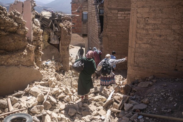 Residents flee their homes after an earthquake in Moulay Brahim village, near the epicenter of the earthquake, outside Marrakech, Morocco, Saturday, Sept. 9, 2023. A rare, powerful earthquake struck Morocco late Friday night, killing more than 800 people and damaging buildings from villages in the Atlas Mountains to the historic city of Marrakech. But the full toll was not known as rescuers struggled to get through boulder-strewn roads to the remote mountain villages hit hardest. (AP Photo/Mosa'ab Elshamy)