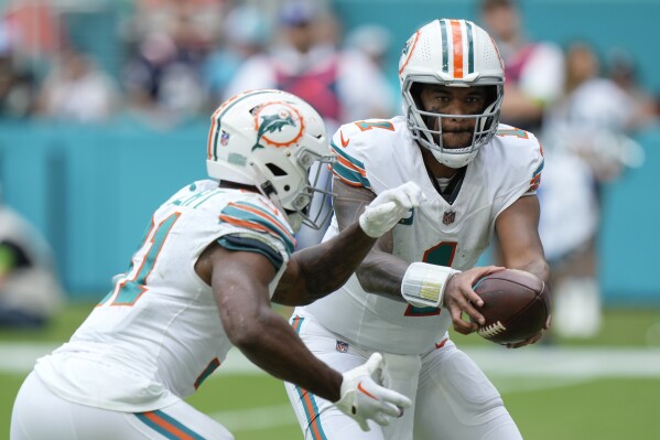 Miami Dolphins quarterback Tua Tagovailoa (1) hands off the ball to Miami Dolphins running back Raheem Mostert (31) during the second half of an NFL football game against the New England Patriots, Sunday, Oct. 29, 2023, in Miami Gardens, Fla. (AP Photo/Wilfredo Lee)