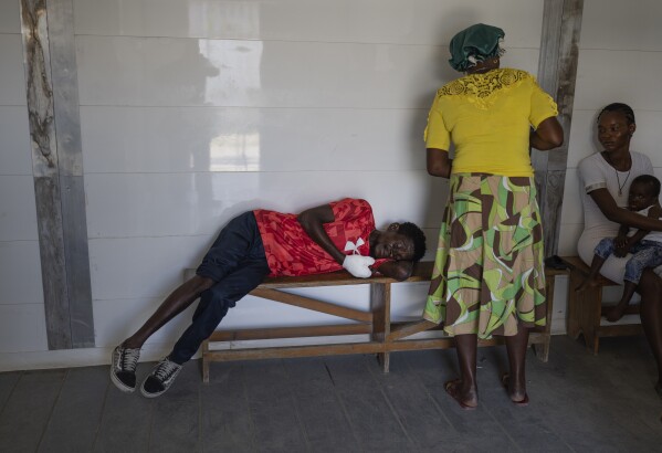 FILE - Marc Baptiste rests on a bench after being treated at a Doctors Without Borders emergency room in the Cite Soleil neighborhood of Port-au-Prince, Haiti, Friday, April 19, 2024. Baptiste said police in an armored vehicle shot him the previous day as he was collecting wood to sell as kindling in an area controlled by gangs. Haiti's health system has long been fragile, but it's now nearing total collapse after gangs launched coordinated attacks on Feb. 29, targeting critical state infrastructure in the capital and beyond. (AP Photo/Ramon Espinosa, File)