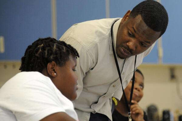 Timothy Allison, a collaborative special education teacher in Birmingham, Ala., works with a student at Sun Valley Elementary School on Thursday, Sept. 8, 2022. The school district is struggling to fill around 50 teaching spots, including 15 in special education, despite $10,000 signing bonuses for special education teachers. (AP Photo/Jay Reeves)