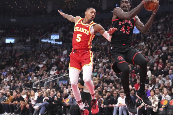 Toronto Raptors forward Pascal Siakam (43) collects a pass as Atlanta Hawks guard Dejounte Murray (5) defends during the first half of an NBA basketball game Friday, Dec. 15, 2023, in Toronto. (Chris Young/The Canadian Press via AP)