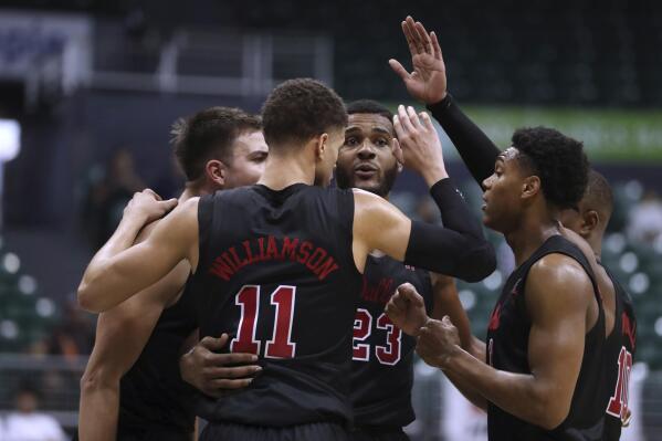 SMU players huddles on the floor during the second half of the team's NCAA college basketball game against Utah State, Friday, Dec. 23, 2022, in Honolulu. SMU defeated Utah State 77-74 to reach the final of the Diamond Head Classic. (AP Photo/Marco Garcia)