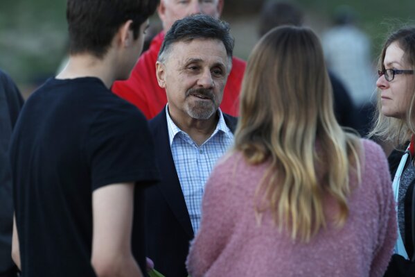 
              Frank DeAngelis, back, greets well-wishers during a vigil at the memorial for the victims of the massacre at Columbine High School on the 20th anniversary of the attack Friday, April 19, 2019, in Littleton, Colo. DeAngelis was principal of the school at the time of the attack. (AP Photo/David Zalubowski)
            