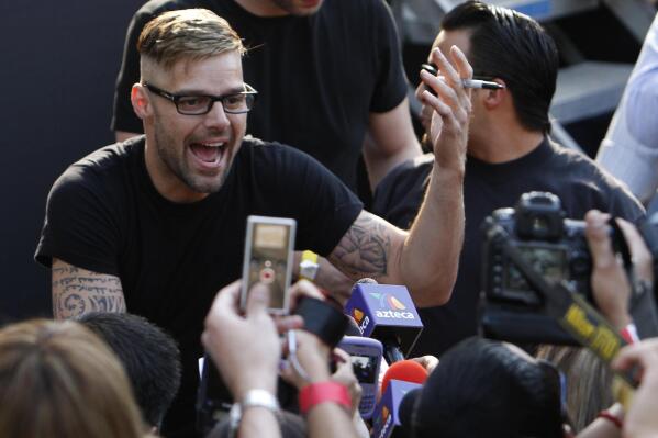 FILE - Puerto Rican pop star Ricky Martin signs autographs in Mexico City, April 5, 2011. A Puerto Rico court has “archived” a restraining order issued against the superstar, meaning the case is closed, a judicial spokesperson said Thursday, July 21, 2022.  (AP Photo/Marco Ugarte, File)