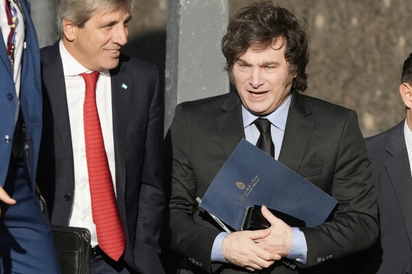 Argentine President Javier Milei, right, and his Economy Minister Luis Caputo enter the Economy Ministry after a meeting with US Treasury Secretary Scott Bessent in Buenos Aires, Argentina, Monday, April 14, 2025. (AP Photo/Natacha Pisarenko)