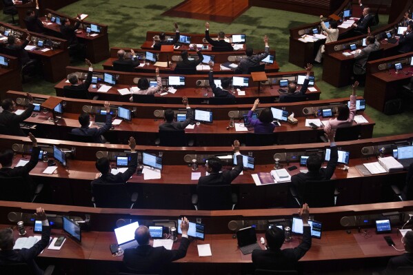 Lawmakers raise their hands to vote after the second reading of the Basic Law Article 23 legislation at the Legislative Council in Hong Kong, Tuesday, March 19, 2024. Hong Kong’s lawmakers unanimously passed a new national security law that grants the government more power to quash dissent in the southern Chinese city. (AP Photo/Louise Delmotte)