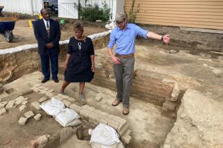FILE - Reginald F. Davis, from left, pastor of First Baptist Church, Connie Matthews Harshaw, a member of First Baptist, and Jack Gary, Colonial Williamsburg's director of archaeology, stand at the brick-and-mortar foundation of one the oldest Black churches in the U.S. on Oct. 6, 2021, in Williamsburg, Va. Archaeologists in Virginia began excavating three suspected graves at the site on Monday, July 18, 2022, commencing a months-long effort to learn who was buried there and how they lived. (AP Photo/Ben Finley, File)