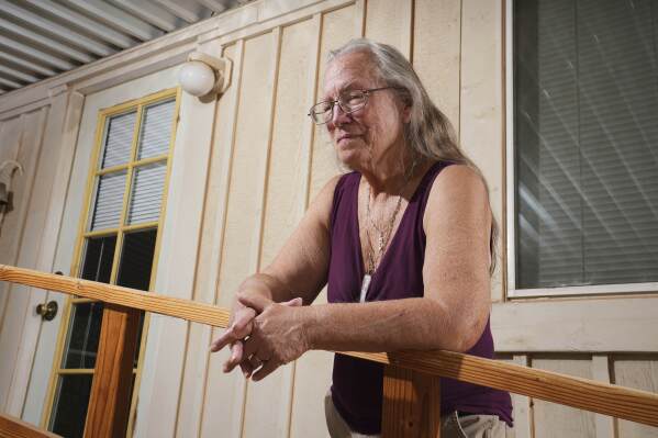 Linda Hilton, a 76-year-old retired office worker, stands in front of her home Tuesday, May 13, 2025, in Apache Junction, Ariz. (AP Photo/Ross D. Franklin)