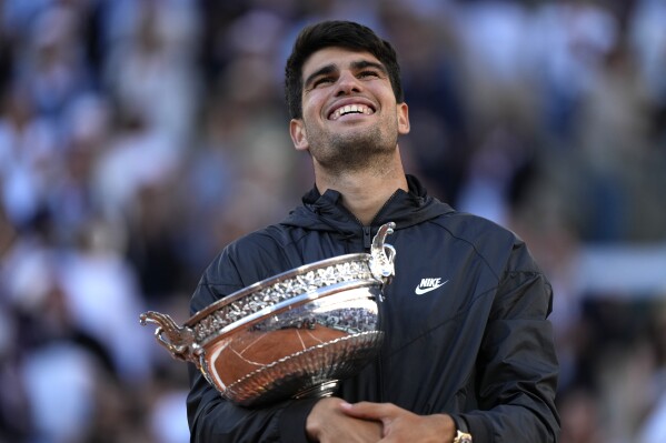 Winner Spain's Carlos Alcaraz celebrates with the trophy as he won the men's final match of the French Open tennis tournament against Germany's Alexander Zverev at the Roland Garros stadium in Paris, Sunday, June 9, 2024. (AP Photo/Thibault Camus)