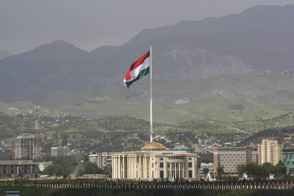 FILE - A national flag of Tajikistan is hoisted to the top of the 165-meter (541.34 feet) flagpole in Dushanbe, Tajikistan, Tuesday, May 24, 2011. The four men charged with the massacre at a Moscow theater have been identified by the Russian government as citizens of Tajikistan, some of the thousands who migrate each year from the poorest of the former Soviet republics to scrape out marginal existences. (AP Photo/Olga Tutubalina, File)