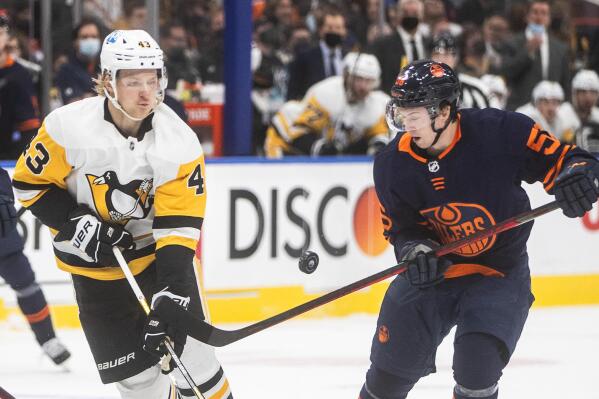 Pittsburgh Penguins' Danton Heinen (43) and Edmonton Oilers' Kailer Yamamoto (56) vie for the puck during the first period of an NHL hockey game Wednesday, Dec 1, 2021, in Edmonton, Alberta. (Jason Franson/The Canadian Press via AP)