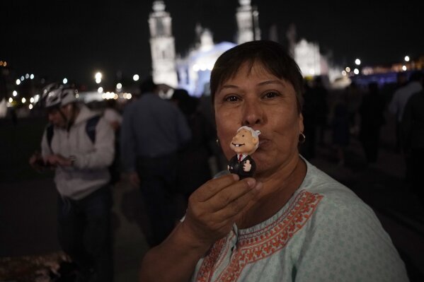 
              A supporter of presidential candidate Andres Manuel Lopez Obrador kisses a doll in the likeness of the candidate as she celebrates his apparent victory, in Mexico City's main square, the Zocalo, Sunday, July 1, 2018. Leftist populist Andres Manuel Lopez Obrador is on the brink of a historic presidential win Sunday night as an exit poll gave him an overwhelming lead and both of his chief rivals conceded defeat. (AP Photo/Ramon Espinosa)
            