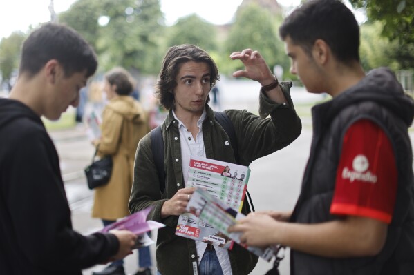 A supporter of the leftist coalition Nouveau Front Populaire (New Popular Front) campaigns for the second round of the legislative election, Thursday, July 4, 2024 in Strasbourg, eastern France. French President Emmanuel Macron called the surprise legislative election on June 9 after his centrist alliance suffered a punishing defeat at the hands of the National Rally in French voting for the European Parliament. (AP Photo/Jean-Francois Badias)