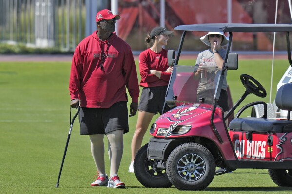 Tampa Bay Buccaneers head coach Todd Bowles walks with a cane as he watches during an NFL football organized team activity Tuesday, May 21, 2024, in Tampa, Fla. Bowles had minor knee surgery earlier this week. (AP Photo/Chris O'Meara)