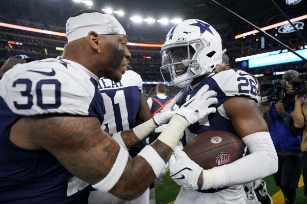 Dallas Cowboys cornerback DaRon Bland, right, celebrates with safety Juanyeh Thomas (30) after returning an interception for a touchdown during the second half of an NFL football game against the Washington Commanders Thursday, Nov. 23, 2023, in Arlington, Texas. (AP Photo/Sam Hodde)