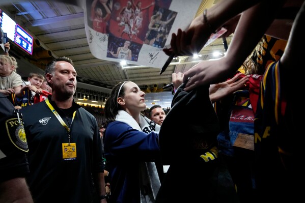 Indiana Fever guard Caitlin Clark signs autographs after an exhibition women's basketball game against Brazil, Sunday, May 4, 2025, in Iowa City, Iowa. (AP Photo/Charlie Neibergall)