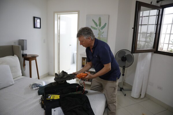 Richard Phillips, a 65-year-old man from the Canadian capital, Ottawa, packs his suitcase in Port-au-Prince, Haiti, Friday, March 8, 2024. Dozens of foreigners, including many from the U.S. and Canada, are stranded in Haiti, desperately trying to leave the violence-torn country where anti-government gangs are battling police and have already shut down both of the country's international airports. (AP Photo/Odelyn Joseph)