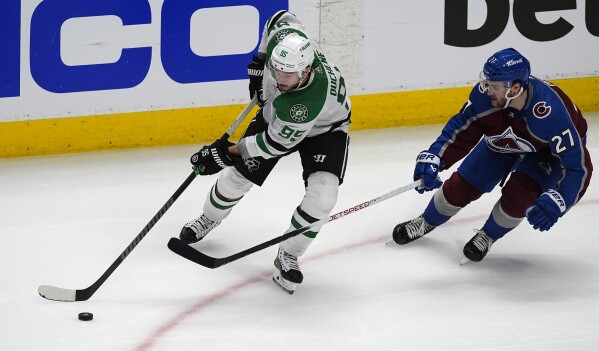 Dallas Stars center Matt Duchene, left, looks to pass the puck as Colorado Avalanche left wing Jonathan Drouin defends in the third period of Game 4 of an NHL hockey Stanley Cup playoff series, Monday, May 13, 2024, in Denver. (AP Photo/David Zalubowski)