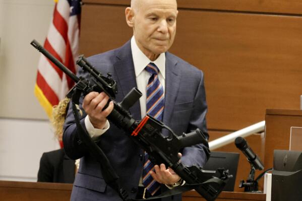 Assistant State Attorney Mike Satz, checks into evidence the weapon used in the MSD shooting during the penalty phase of shooter Nikolas Cruz at the Broward County Courthouse in Fort Lauderdale on Monday, July 25, 2022. Cruz previously plead guilty to all 17 counts of premeditated murder and 17 counts of attempted murder in the 2018 shootings. (Carline Jean/ Florida Sun Sentinel via AP, Pool)