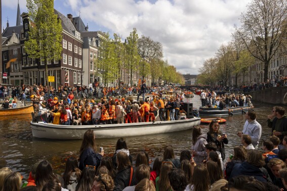 Orange crush: Boats packed with revelers tour Amsterdam canals to celebrate the king’s birthday