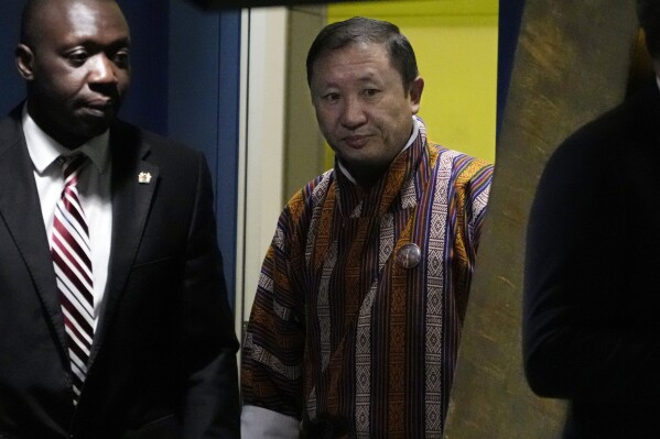 Bhutan's Foreign Minister Tandi Dorji, center, is escorted to address the 78th session of the United Nations General Assembly, Tuesday, Sept. 26, 2023. (AP Photo/Richard Drew)