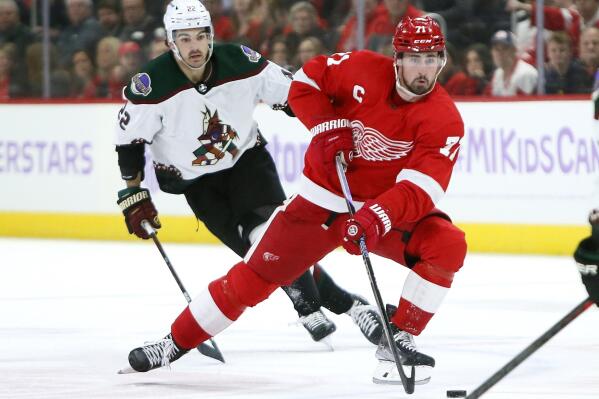 Detroit Red Wings center Dylan Larkin (71) takes the puck past Arizona Coyotes center Jack McBain (22) during the first period of an NHL hockey game Friday, Nov. 25, 2022, in Detroit. (AP Photo/Duane Burleson)