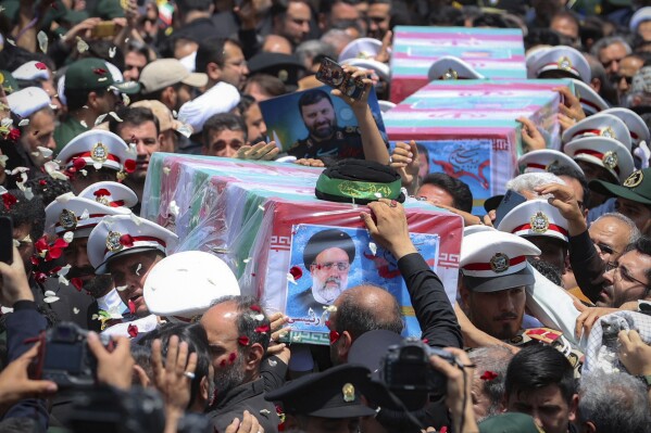 In this photo released by the Iranian Presidency Office, flag-draped coffins of the President Ebrahim Raisi and his companions who were killed in a helicopter crash on Sunday, are carried during their funeral ceremony in the city of Mashhad, Iran, Thursday, May 23, 2024. Iran on Thursday prepared to inter its late president at the holiest site for Shiite Muslims in the Islamic Republic, a final sign of respect for a protégé of Iran's supreme leader killed in a helicopter crash earlier this week. (Iranian Presidency Office via AP)