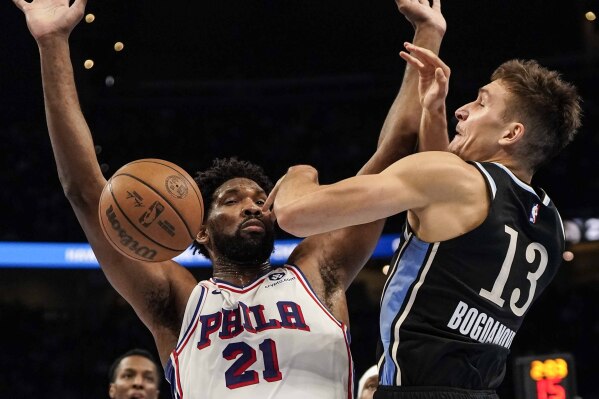 Atlanta Hawks guard Bogdan Bogdanovic (13) collides into Philadelphia 76ers center Joel Embiid (21) during the first half of an In-Season Tournament NBA basketball game, Friday, Nov. 17, 2023, in Atlanta. (AP Photo/Mike Stewart)