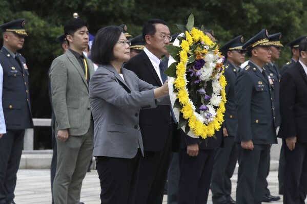 Taiwan's President Tsai Ing-wen carries the wreath during a ceremony commemorating the 65th anniversary of deadly attack by China on Kinmen island, in Kinmen, Taiwan, Wednesday, Aug. 23, 2023. (AP Photo/Chiang Ying-ying)
