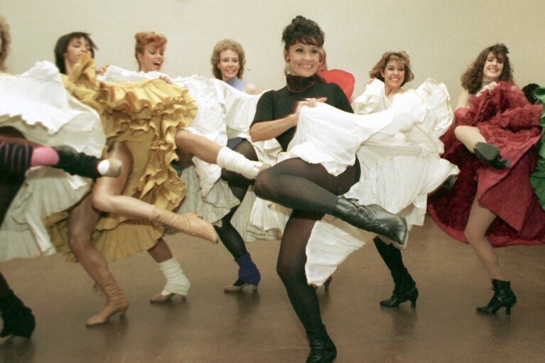 FILE - Broadway star Chita Rivera, foreground, and the Radio City Music Hall Rockettes rehearse Cole Porter's "Can Can" in New York on Jan. 21, 1988. Rivera, the dynamic dancer, singer and actress who garnered 10 Tony nominations, winning twice, in a long Broadway career that forged a path for Latina artists, died Tuesday. She was 91. (AP Photo/Marty Lederhandler, File)