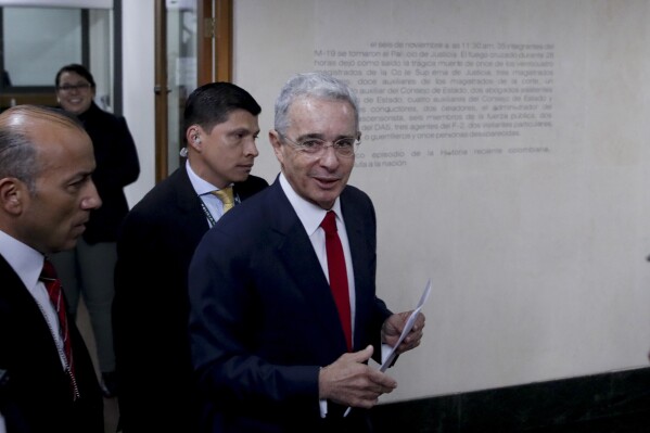 FILE - Senator and former president Alvaro Uribe arrives to the Supreme Court for questioning in an investigation for witness tampering charges in Bogota, Colombia, Oct. 8, 2019. Colombian prosecutors said Tuesday, April 9, 2024 that they will call Uribe to trial for the alleged crimes of bribery of witnesses in criminal proceedings and procedural fraud, which would make him the first former Colombian president to face trial. (AP Photo/Ivan Valencia, File)