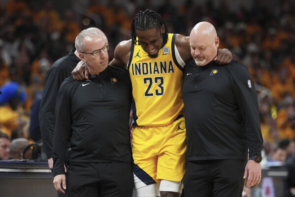 Indiana Pacers forward Aaron Nesmith (23) is assisted off the court during the second half of Game 3 of the Eastern Conference finals of the NBA basketball playoffs against the New York Knicks Sunday, May 25, 2025, in Indianapolis. (AP Photo/AJ Mast)