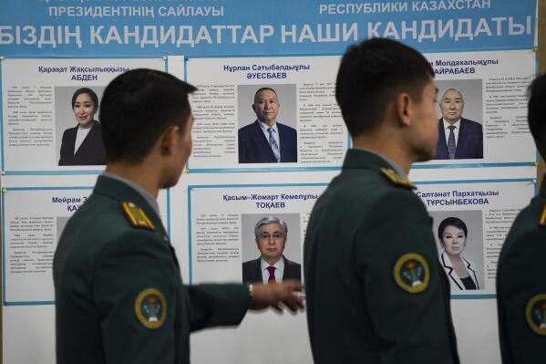 National servicemen lineup to cast their votes next to a poster showing presidential candidates at a polling station in Almaty, Kazakhstan, Sunday, Nov. 20, 2022. Kazakhstan's president appears certain to win a new term against little-known challengers in a snap election on Sunday. Five candidates are on the ballot against President Kassym-Jomart Tokayev, who faced a bloody outburst of unrest early this year and then moved to marginalize some of the Central Asian country's longtime powerful figures. (Vladimir Tretyakov/NUR.KZ via AP)