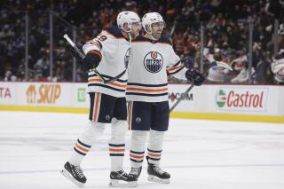 Edmonton Oilers' Leon Draisaitl, left, of Germany, and Evan Bouchard celebrate Draisaitl's goal against the Vancouver Canucks during the third period of an NHL hockey game, Tuesday, Jan. 25, 2022 in Vancouver, British Columbia. (Darryl Dyck/The Canadian Press via AP)