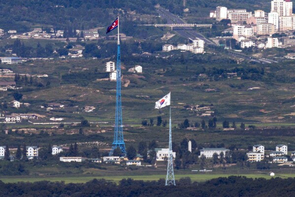 FILE - Flags of North Korea, rear, and South Korea, front, flutter in the wind as pictured from the border area between two Koreas in Paju, South Korea, on Aug. 9, 2021. South Korea said Monday, Nov. 6, 2023, it plans to launch its first domestically built spy satellite at the end of this month as part of its efforts to better monitor rival North Korea and deter its potential aggressions.(Im Byung-shik/Yonhap via AP, File)