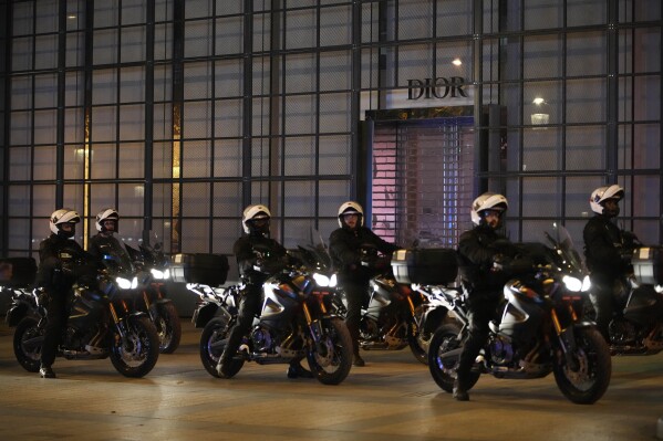 Police officers on motorcycles patrol on the Champs Elysees in Paris, Saturday, July 1, 2023. President Emmanuel Macron on Saturday scrapped an official trip to Germany after a fourth straight night of rioting and looting across France in defiance of a massive police deployment. Hundreds turned out for the burial of the 17-year-old whose killing by police triggered the unrest. (AP Photo/Christophe Ena)