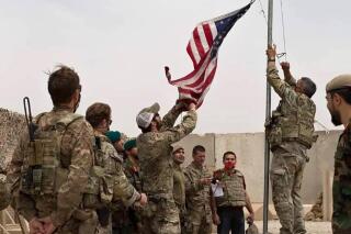 A U.S. flag is lowered as American and Afghan soldiers attend a handover ceremony from the U.S. Army to the Afghan National Army, at Camp Anthonic, in Helmand province, southern Afghanistan, Sunday, May 2, 2021. (Afghan Ministry of Defense Press Office via AP)