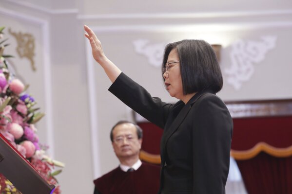 In this photo released by the Taiwan Presidential Office, Taiwanese President Tsai Ing-wen raises her hand during an inauguration ceremony at the Presidential office in Taipei, Taiwan Wednesday, May 20, 2020. President Tsai been inaugurated for a second term amid increasing pressure from China on the self-governing island democracy it claims as its own territory. (Taiwan Presidential Office via AP)