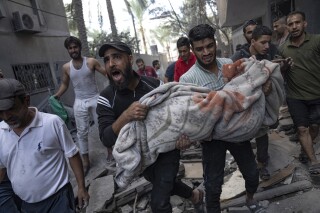 Palestinians evacuate wounded from a building destroyed in Israeli bombardment in Rafah refugee camp in Gaza Strip on Tuesday, Oct. 17, 2023. (AP Photo/Fatima Shbair)