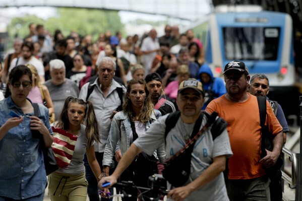 Pasażerowie wysiadają z pociągu na stacji Retiro w Buenos Aires, Argentyna, środa, 13 grudnia 2023 r. Rząd Argentyny ograniczył dotacje na transport i energię, a także zdewaluował peso o 50% w ramach niespodziewanych posunięć nowego prezydenta Javiera Mileya .  Jego zdaniem należy uporać się z kryzysem gospodarczym.  (AP Photo/Natasha Pisarenko)