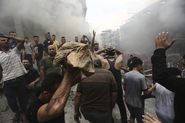 Palestinians react after removing a dead body from the rubble of a building after an Israeli airstrike in Jebaliya refugee camp, Gaza Strip, Monday, Oct. 9, 2023. (AP Photo/Ramez Mahmoud )