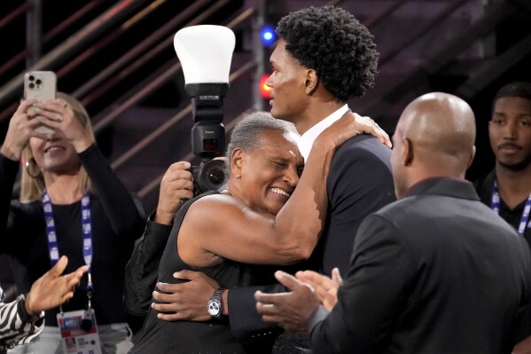 Ausar Thompson, right, hugs family and friends after being selected fifth overall by the Detroit Pistons during the NBA basketball draft, Thursday, June 22, 2023, in New York. (AP Photo/John Minchillo)