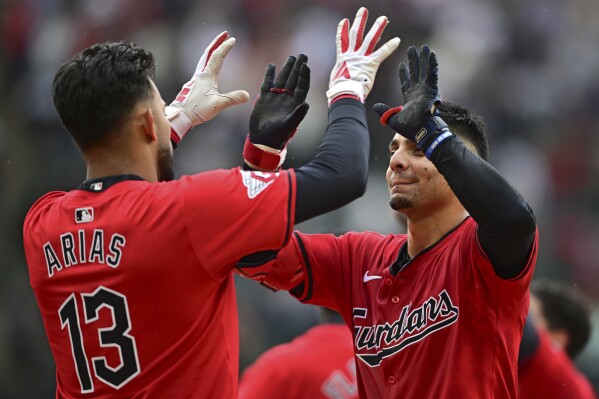 Cleveland Guardians' Andres Gimenez, right, celebrates with Gabriel Arias, left, after hitting a walkoff sacrifice fly in the 10th inning of a baseball game against the New York Yankees, Sunday, April 14, 2024, in Cleveland. (AP Photo/David Dermer)