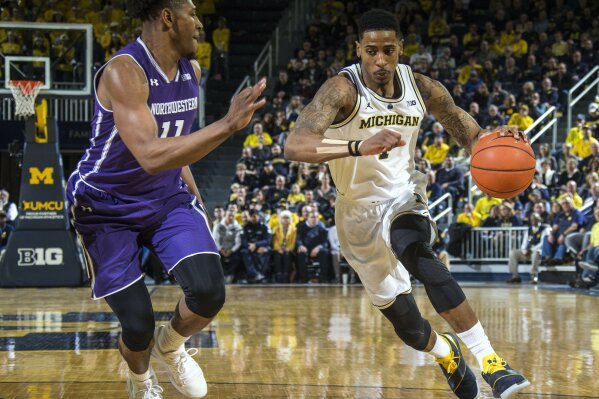 
              Northwestern guard Anthony Gaines (11) defends Michigan guard Charles Matthews, right, in the second half of an NCAA college basketball game in Ann Arbor, Mich., Sunday, Jan. 13, 2019. Michigan won 80-60. (AP Photo/Tony Ding)
            