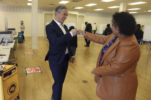 California Attorney General Rob Bonta, left, fist bumps his wife Assemblymember Mia Bonta after the couple dropped off their ballots at a voting center on Tuesday, Nov. 8, 2022, in Alameda, Calif. (Aric Crabb/Bay Area News Group via AP)