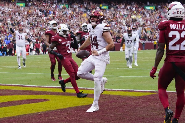 Washington Commanders quarterback Sam Howell (14) runs in for a touchdown against the Arizona Cardinals during the second half of an NFL football game at FedEx Field in Landover, Md., Sunday, Sept. 10, 2023. Washington 20-16. (AP Photo/Susan Walsh)