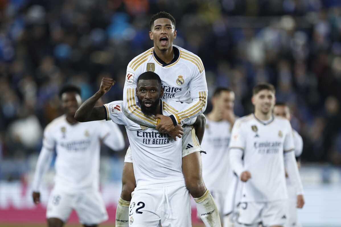 Real Madrid's Antonio Rudiger, centre, and Real Madrid's Jude Bellingham celebrate their victory at the Spanish La Liga soccer match between Alaves and Real Madrid at the Mendizorroza stadium in Vitoria-Gasteiz, Spain, Thursday, Dec. 21, 2023. (AP Photo/Ricardo Larreina)