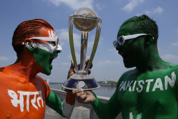Indian cricket fans, their bodies painted in the colors of the national flags of India and Pakistan, pose for photographs in Ahmedabad, India, Wednesday, Oct. 11, 2023. India and Pakistan will play their World Cup match in Ahmedabad on Saturday. (AP Photo/Ajit Solanki)